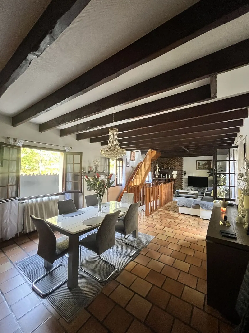 Séjour d’une maison avec poutres apparentes vendue par Horizons Immobilier en Île-de-France